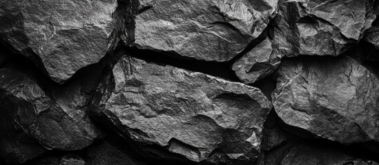 Poster - Textured black stone wall background with prominent rock formations and varying surface details Copy Space