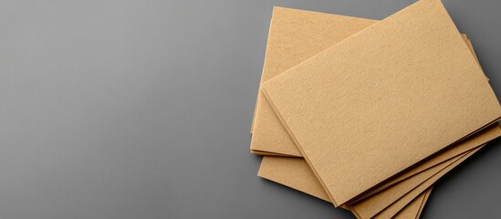 Poster - Stack of brown kraft paper envelopes on a gray background with copy space for text or design elements