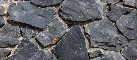 Poster - Textured slate stone wall in shades of gray with irregular shapes and lines suitable for background use. Copy Space.