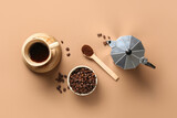 Cup of hot coffee with beans, powder and geyser coffee maker on brown background