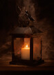 © Jay Himes Photo - A candle is lit in a lantern, with smoke coming out of it. The lantern is on a wooden table