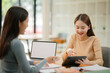 © aekachai - A focused team of business professionals is working together around a wooden table.