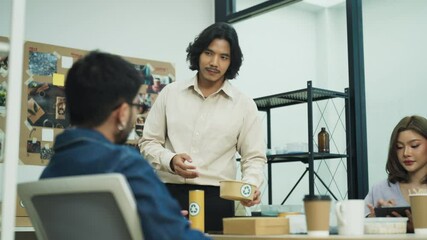 Sticker - Diverse group of professionals engaging in a creative discussion in a modern office setting, sharing ideas with a document in hand and surrounded by coffee cups and materials