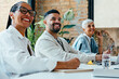 © (JLco) Julia Amaral - Smiling business professionals taking notes during a collaborative meeting in a sunlit office with lush indoor plants