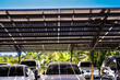 © ultramansk - Engineer in safety vest and helmet pointing towards a solar powered carport, illustrating eco-friendly innovation in parking infrastructure. Solar panels provide shade and sustainable energy.