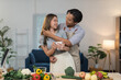 © crizzystudio - Young asian couple embracing affectionately in their kitchen while preparing a healthy meal with fresh fruits and vegetables, enjoying a moment of love and togetherness