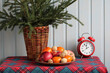 © MaskaRad - Christmas still life with fir branches, fruits, nuts and red alarm clock showing midnight. New Year's Eve atmosphere in a wooden cottage