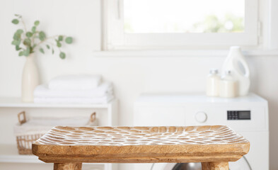 Wall Mural - Carved empty wooden table for product display on blurred laundry room background