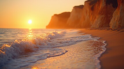 Wall Mural - Golden sunset reflecting on calm waves along a sandy beach near rocky cliffs, creating a serene evening atmosphere