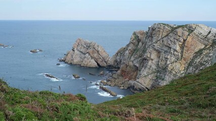 Wall Mural - A rocky shoreline with a large body of water in the background