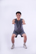 © NETI studio - Full body image of Asian guy wearing gym clothes and posing on a white background