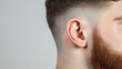 © olga_demina - Capturing a close up of a man's ear and surrounding area, highlighting hearing issues like loss, tinnitus, or infection while emphasizing ear health and audiology