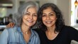 © ifoto - A portrait of two middle-aged Indian women, smiling and posing for the camera in their kitchen.