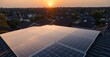 © Pro Creator - Aerial view of residential rooftops with solar panels at sunset, orange sky blending with a suburban landscape,, Solar panels on the roof of a residential urban area at sunset