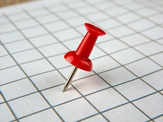 Red push pin isolated on a clean backdrop, perfect for visualizing reminders or office supplies.