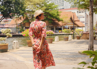 Young woman in ethnic dress and hat exploring the vibrant streets of Malacca, Malaysia. A blend of cultural heritage, colorful architecture, and tropical charm. Perfect travel and lifestyle moments.