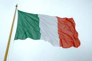 Wall Mural - A large Italian flag flies high in the blue sky, perfect for patriotic or cultural events