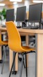 © Sergey - A modern office interior with sleek design featuring yellow chairs and computers on a wooden desk, embodying a clean and contemporary work environment.