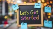 © MD NAZMUL - Close-up of a blue clipboard holding colorful sticky notes with the motivational message 'Let's get started,' symbolizing productivity, planning, and taking action.