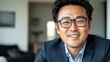 © Evon J - Smiling asian male adult in glasses and suit in bright room
