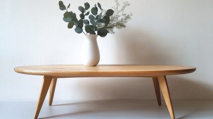 Poster - Minimalist wooden coffee table with vase of greenery against a plain wall offering Copy Space for text placement