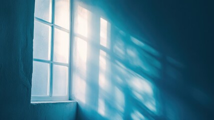 Poster - Light shining through a window casting shadows on a blue wall with soft illumination and Copy Space for text placement