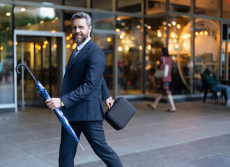 Wall Mural - Walking to office. Businessman outdoor. Businessman in suit with suitcase, copy space. Mature Hispanic businessman. Boss man in business. Successful business. Success of entrepreneur. Office manager