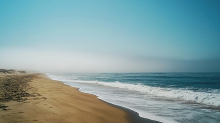 Poster - Foggy beach landscape with gentle waves and golden sand, serene shoreline with Copy Space for text placement