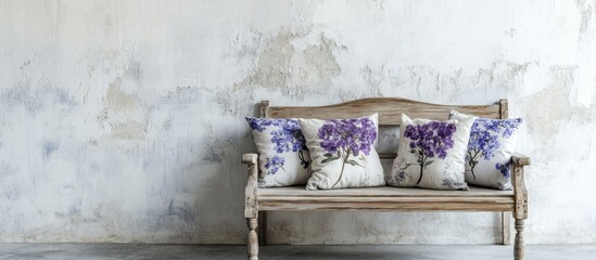 Poster - Vintage wooden bench with floral cushions against a textured wall with copy space for text or graphics