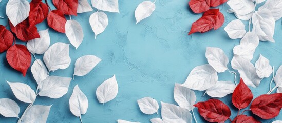 Poster - Vibrant foliage arrangement with red and white textured leaves on a cyan blue background creating a stylish space for your text or designs