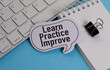 © Pawel - LEARN PRACTICE IMPROVE. text on white paper on blue background