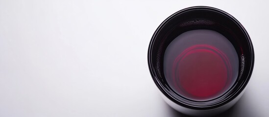 Poster - camera lens with deep red reflection on clean white background ideal for wine manufacturing product 