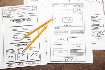 Leinwandbilder - Developing UI design. Sketches of website wireframes and pencils on wooden table, top view
