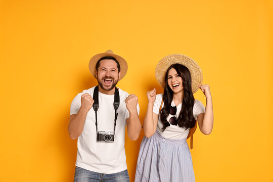 Wall Mural -  - tourism. emotional couple in hats with camera on yellow background