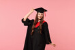 © New Africa - Happy student after graduation on pink background