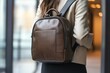 © Nyxoria - Woman wearing a stylish brown leather backpack in a modern indoor setting during daylight