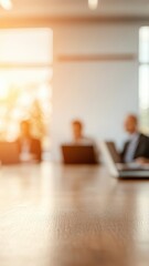 Poster - Blurry meeting scene with professionals working on laptops in a modern office setting.