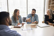 © fizkes - Multiethnic teammates listening speech of skilled Hispanic colleague, make speech, encouraging team members to contribute new ideas or approaches, share opinion, take part in corporate briefing event