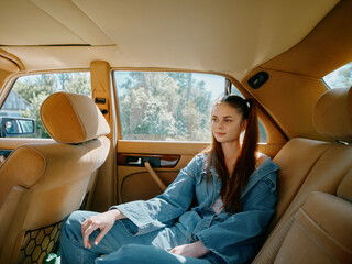 Poster - Young woman in denim clothing sitting in a vintage car interior, conveying a relaxed emotion while enjoying a sunny day.