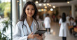 © Danny - Smiling Female Doctor Holding a Tablet in a Bright Hospital Hallway - Concept of Compassionate Care and Modern Healthcare Technology