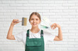 © Pixel-Shot - Female decorator with color palettes and brush on white brick background