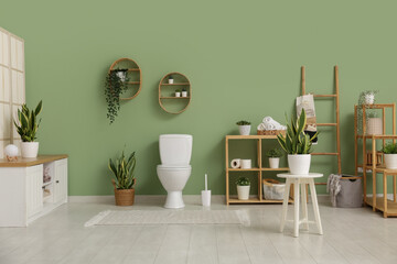 Wall Mural - Interior of stylish bathroom with houseplants and ceramic toilet bowl near green wall