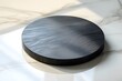 © riyan kusuma - Round dark wooden surface on a marble table, illuminated by soft natural light, ideal for product display