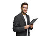 © muse studio - Young man in a suit smiling while holding a tablet in a bright setting