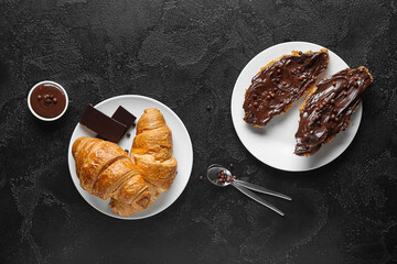 Wall Mural - Plate of sweet croissants with chocolate spread on black background