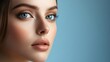© HISTOCK - Beautiful woman with perfect skin and blue eyes posing on blue background