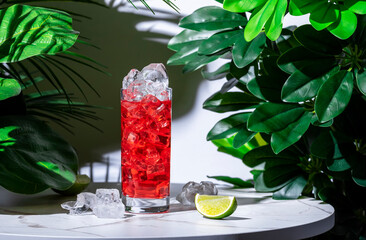 Sticker - Pink gin and tonic alcoholic cocktail drink with gin, lime juice, bitters, chilled tonic water and ice. White marble table with tropical leaves