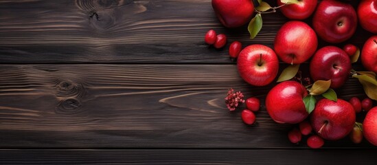 Poster - Red apples arranged on a dark wooden background in a flat lay composition with green leaves and ample copy space for creative text placement