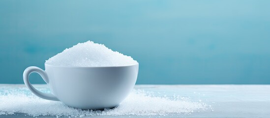 Poster - White cup filled with coarse sea salt centered on a light blue surface with ample negative space for design elements or text placement.