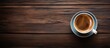 © meristock - Aerial view of a gray cup of espresso on dark wooden surface with rich coffee color filling the cup surrounded by ample negative space for text